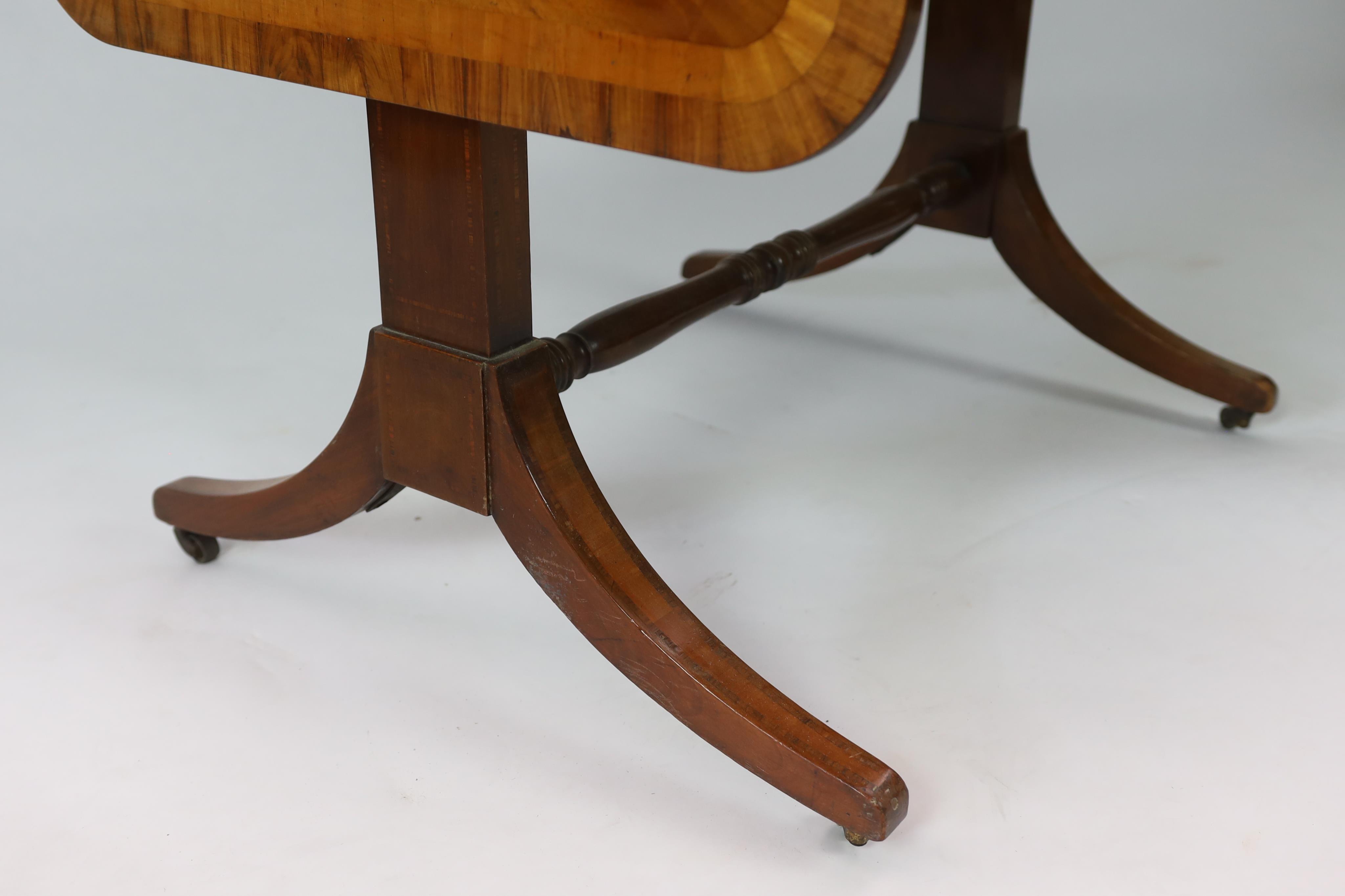 A Regency satinwood banded mahogany sofa table, with two frieze drawers on end standards with turned stretcher and downswept legs, fitted brass castors, width 80cm, depth 64cm, height 71cm. Condition - fair